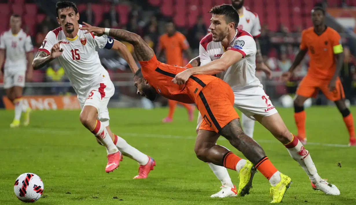 Penyerang timnas Belanda, Memphis Depay dilanggar di kotak penalti oleh gelandang Montenegro Dusan Lagator pada laga lanjutan kualifikasi Piala Dunia 2022 di Stadion Phillips, Minggu (5/8/2021) dini hari WIB. Belanda sukses menghantam Montenegro dengan skor 4-0. (AP Photo/Peter Dejong)