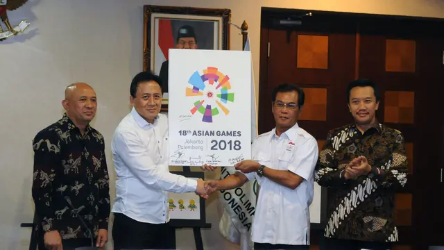 Kepala Barekraf, Triawan Munaf (kedua kiri) menyerahkan logo baru Asean Games 2018 kepada  Wakil Ketua Umum KOI Muddai Maddang usai diperkenalkan di Kantor KSP Jakarta, Kamis (28/7/2016).  Logo bertema The Energy of Asia. (Liputan6.com/Helmi Fithriansyah)