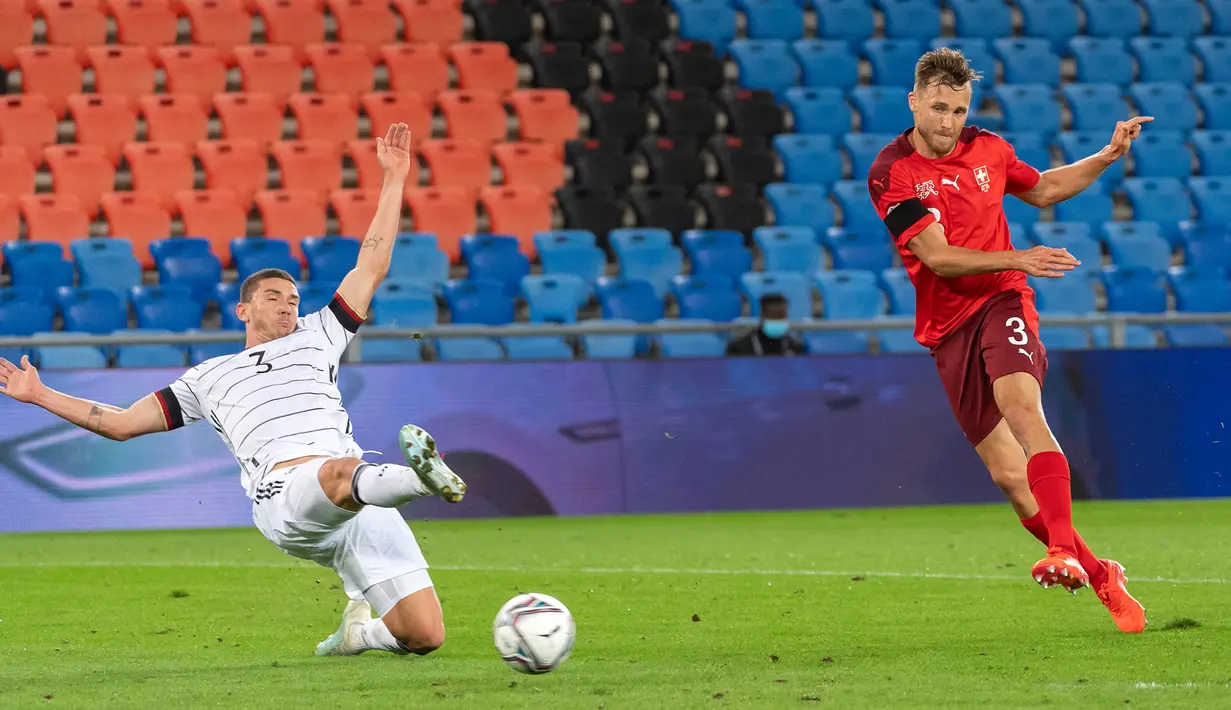 Bek Timnas Swiss, Silvan Widmer mencetak gol melewati Robin Gosens dari Jerman pada pertandingan kedua Liga A Grup 4 UEFA Nations League di St Jakob Park, Senin (7/9/2020) dini hari. Sementara itu Jerman dipaksa bermain imbang 1-1 oleh tuan rumah Swiss. (Georgios Kefalas/Keystone via AP)