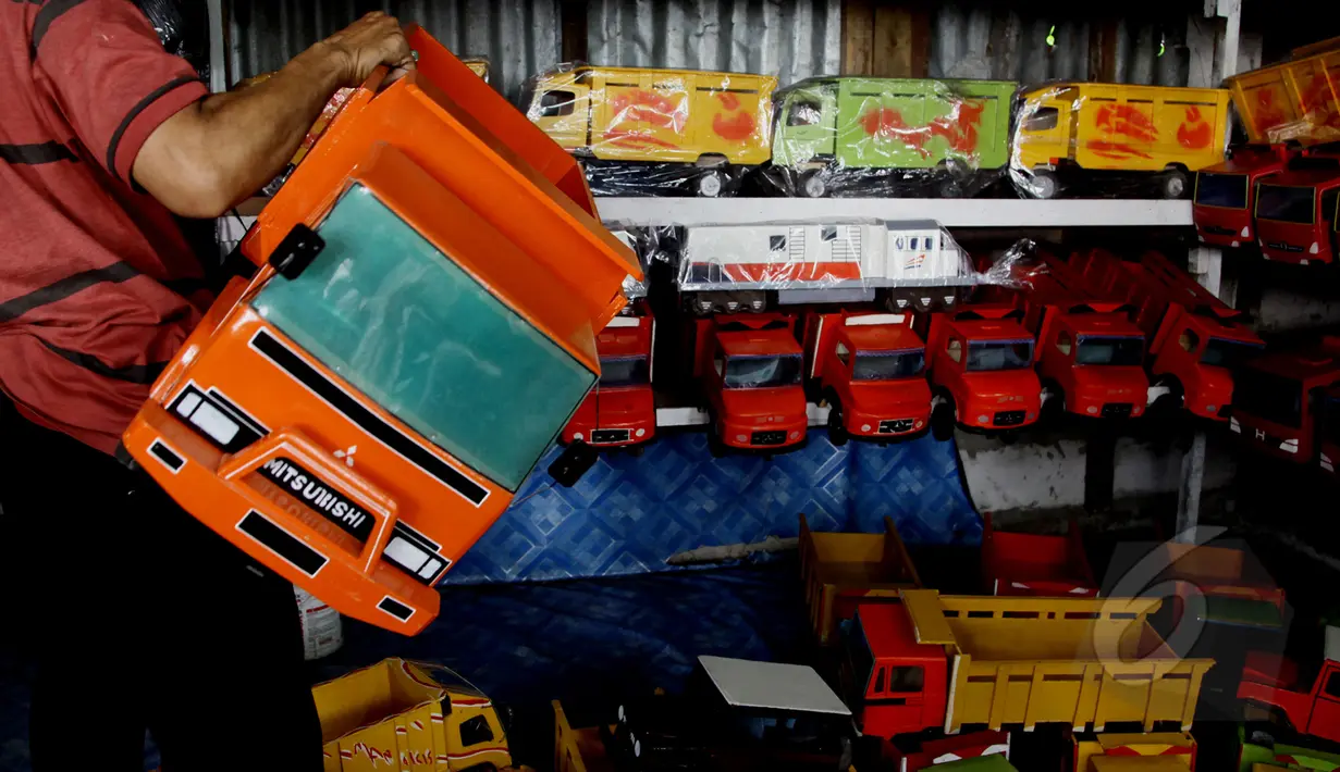 Sebuah mainan mobil kayu ditawarkan di kios mainan kayu di kawasan Kalibata, Jakarta (27/5/2015). Produksi mainan lokal dan tradisional diharapkan mampu bertahan, mengingat pasar bebas Asean yang dimulai Januari 2016 mendatang. (Liputan6.com/Johan Tallo)