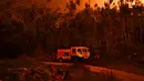 Petugas damkar beristirahat saat memadamkan api yang membakar hutan di Penela, Portugal Tengah, Minggu (18/6). Ratusan petugas pemadam kebakaran dan 160 kendaraan dikirim Sabtu malam untuk mengatasi kobaran api. (PATRICIA DE MELO MOREIRA/AFP)