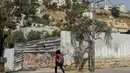 Seorang gadis Palestina berjalan melewati gang menuju Masjid Qaqaa Bin Amr, di lingkungan Silwan, Yerusalem (15/9/2020). Dalam perintah tersebut, pihak berwenang Israel menyebut bangunan masjid itu harus dihancurkan karena dibangun tanpa izin. (AFP/AHMAD GHARABL)