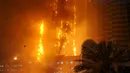 Sejumlah orang berkumpul melihat kebakaran yang melanda gedung apartemen mewah di Ajman, Uni Emirat Arab (UEA), Senin (28/3). Insiden kebakaran kali ini adalah yang ketiga selama Februari 2015 sampai saat ini. (REUTERS/Stringer)