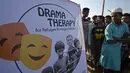 Sejumlah pengungsi Rohingya menonton hiburan dari kelompok teater Drama Therapy di kamp pengungsi Kutupalong, Bangladesh (28/10). (AFP Photo/Tauseef Mustafa)