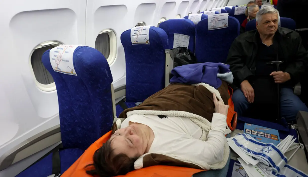 Pengungsi Yahudi Ukraina dan imigran baru dengan kesehatan buruk yang melarikan diri dari perang di negara mereka menunggu untuk turun dari pesawat setibanya di Bandara Ben Gurion, Tel Aviv, Israel, 22 Desember 2022. Sebanyak 100 orang Yahudi Ukraina tiba di Israel, termasuk beberapa penumpang yang terbaring di tempat tidur dan dalam kondisi sakit. (GIL COHEN-MAGEN/AFP)