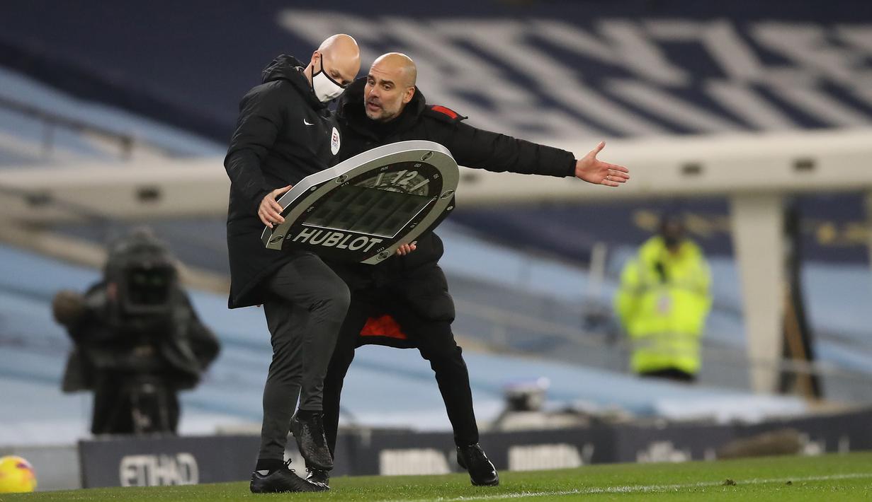 Pelatih Manchester City, Pep Guardiola, berbicara kepada ofisial wasit saat pertandingan melawan West Brom pada laga lanjutan Liga Inggris di Etihad Stadium, Rabu (16/12/2020). Pep Guardiola melakukan protes karena durasi injury time yang dianggap sedikit. (AFP/ Martin Rickett/pool)