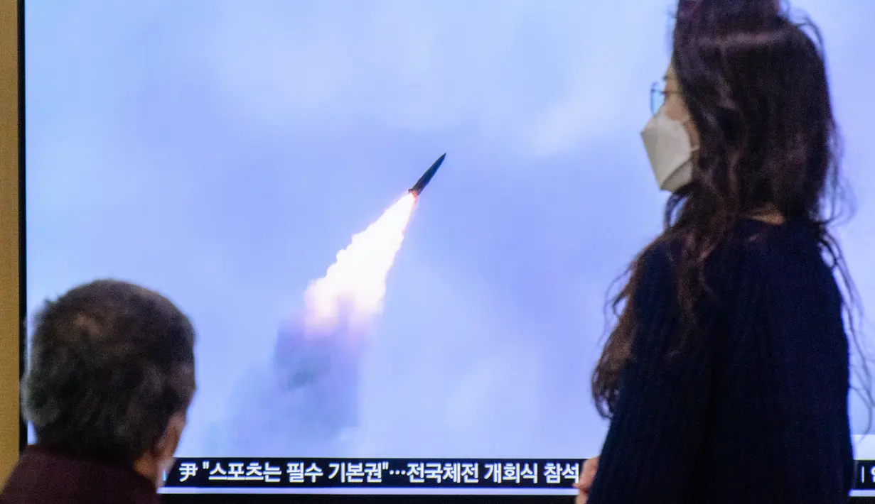 Orang-orang menonton layar televisi yang menayangkan siaran berita dengan cuplikan file uji coba rudal Korea Utara, di sebuah stasiun kereta api di Seoul, Korea Selatan, Minggu (9/10/2022). Rudal itu sepertinya jatuh di luar zona ekonomi eksklusif Jepang, kata pemerintah Jepang. (Photo by ANTHONY WALLACE / AFP)