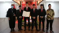 Pemain Naturalisasi Timnas Indonesia, Shayne Pattynama (tengah kiri) dan Ketua Umum PSSI, Mochamad Iriawan (tengah kanan) berfoto bersama dengan para petugas pengambil sumpah sambil memegang Surat Keputusan Presiden Republik Indonesia Tentang Pemberian Kewarganegaraan Republik Indonesia saat Pengambilan Sumpah Janji Setia Pewarganegaraan Republik Indonesia yang berlangsung di Kantor Wilayah Kementetian Hukum dan HAM DKI Jakarta, Selasa (24/01/2023). (Bola.com/Bagaskara Lazuardi)