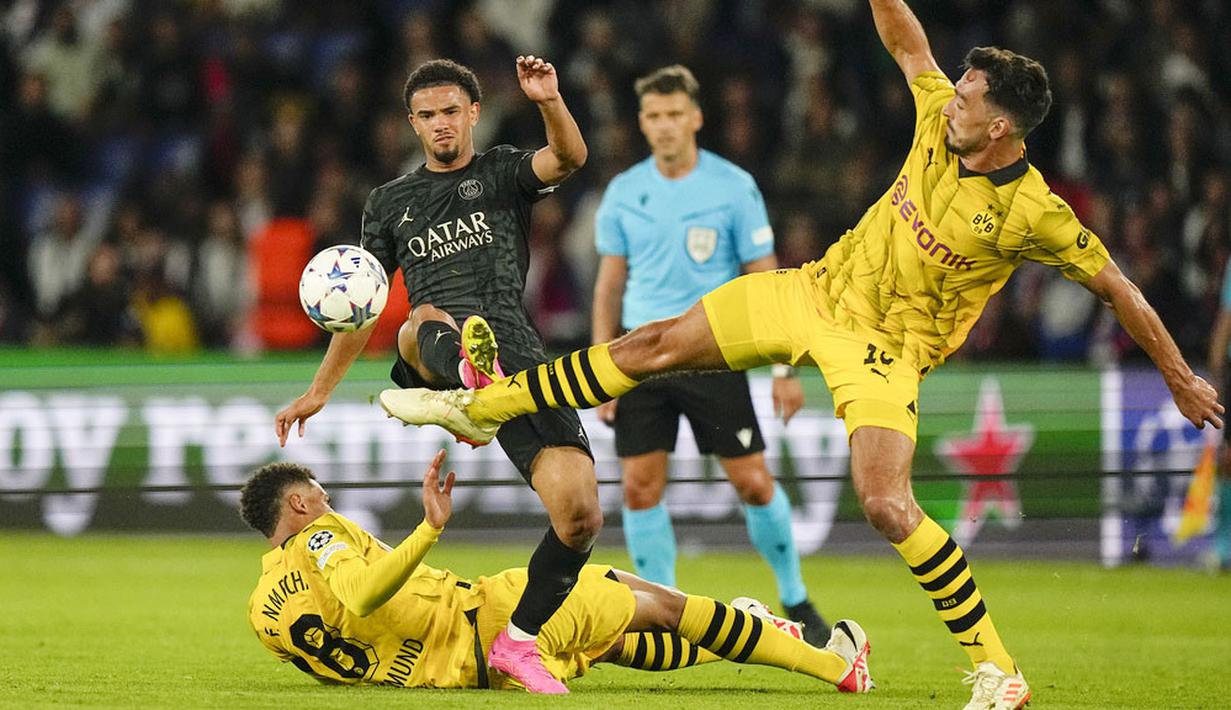 Pemain Paris Saint-Germain (PSG), Warren Zaire-Emery, berebut bola dengan pemain Borussia Dortmund, Mats Hummels, pada laga Liga Champions di Stadion Parc des Princes, Rabu (20/9/2023). PSG menang dengan skor 2-0. (AP Photo/Michel Euler)