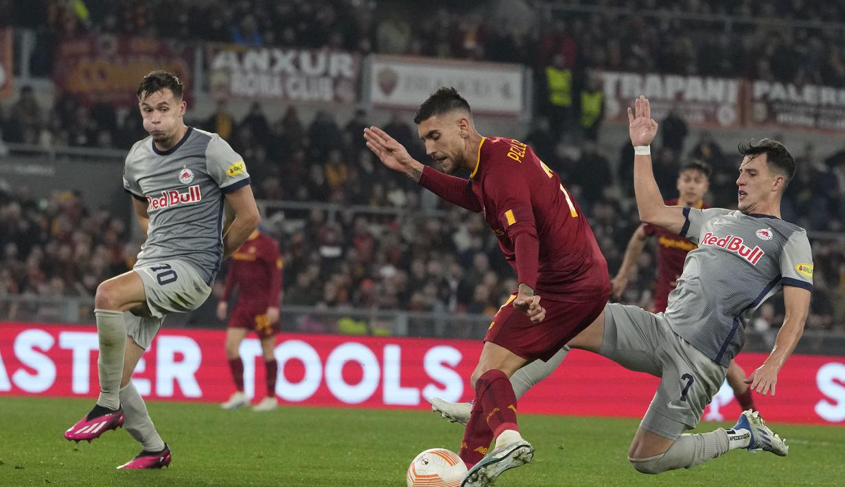 Gelandang AS Roma, Lorenzo Pellegrini berusaha mengumpan bola dari kawalan pemain RB Salzburg, Nicolas Capaldo selama pertandingan leg kedua playoff Liga Europa 2022/2023 di Stadion Olimpico, Jumat (24/2/2023). Kemenangan ini mengantar Roma lolos ke babak 16 besar. Pasukan Jose Mourinho unggul 2-1 secara agregat atas RB Salzburg. (AP Photo/Alessandra Tarantino)