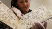 Konservator, Marie Sviergula memperlihatkan penggalan naskah Al-Quran tertua di dunia di Universitas Birmingham, Inggris, Rabu (22/7/2015). Penanggalan radiokarbon menunjukkan manuskrip itu berusia setidaknya 1.370 tahun. (REUTERS/Peter Nicholls)