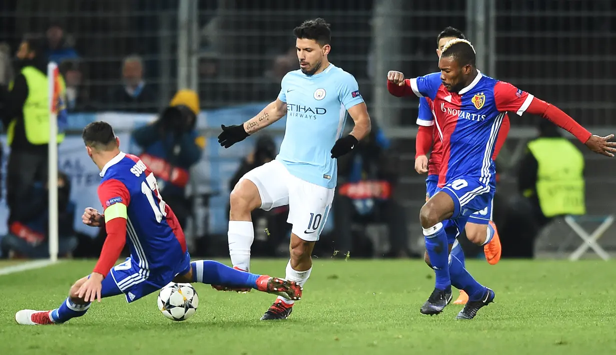 Pemain Manchester City, Sergio Aguero berebut bola dengan pemain FC Basel, Marek Suchy dan Geoffroy Serey Die pada leg pertama babak 16 besar Liga Champions di St. Jakob Park, Rabu (14/2). Manchester City menang 4-0. (SEBASTIEN BOZON/AFP)