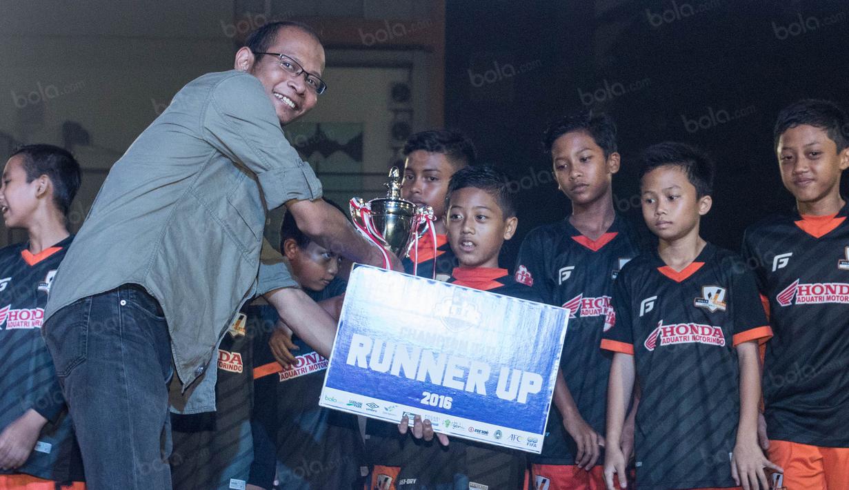 Redaktur Pelaksana, Tjatur Wiharyo, memberikan piala kepada pemain Villa 2000 selaku runner-up turnamen kelas Championship pada Liga Bola Indonesia. (Bola.com/Vitalis Yogi Trisna)