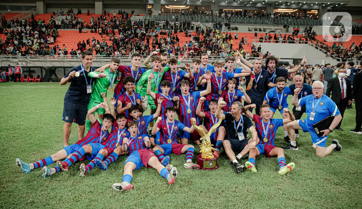 Para pemain Barcelona U-18 berpose untuk foto usai menjadi juara International Youth Championship (IYC) 2021 di Jakarta International Stadium (JIS), Jakarta, Selasa (19/4/2022). Barcelona U-18 juara IYC 2021 usai menang atas Altetico Madrid U-18. (Liputan6.com/Faizal Fanani)