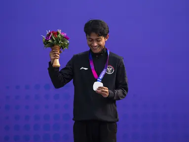 Atlet skateboard Indonesia Sanggoe Darma Tanjung menunjukkan medali usai final street putra Asian Games 2023 di Hangzhou, China, Rabu (27/9/2023). (AP Photo/Louise Delmotte)