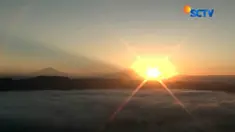 Melihat matahari terbit sambil menikmati sensasi duduk di atas awan saat berkunjung ke Bukit Brujul di Kebumen, Jawa Tengah.