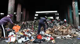 Pemulung memilah sampah di kolong Tol Wiyoto-Wiyono, Sungai Bambu, Jakarta, Selasa (15/1). Kolong Tol tersebut berubah menjadi tempat penampungan sampah warga di 3 kelurahan sehingga menyebabkan pencemaran lingkungan. (Merdeka.com/Iqbal S. Nugroho)