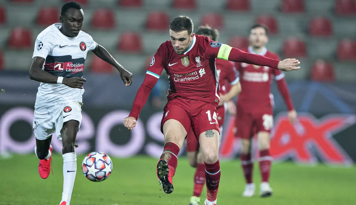 Gelandang Liverpool, Jordan Henderson mengumpan bola dari kawalan pemain Midtjylland, Pione Sisto pada pertandingan Grup D Liga Champions di MCH Arena di Herning, Denmark, Kamis (10/12/2020). Liverpool bermain imbang atas Midtjylland 1-1. (Henning Bagger/Scanpix via AP)