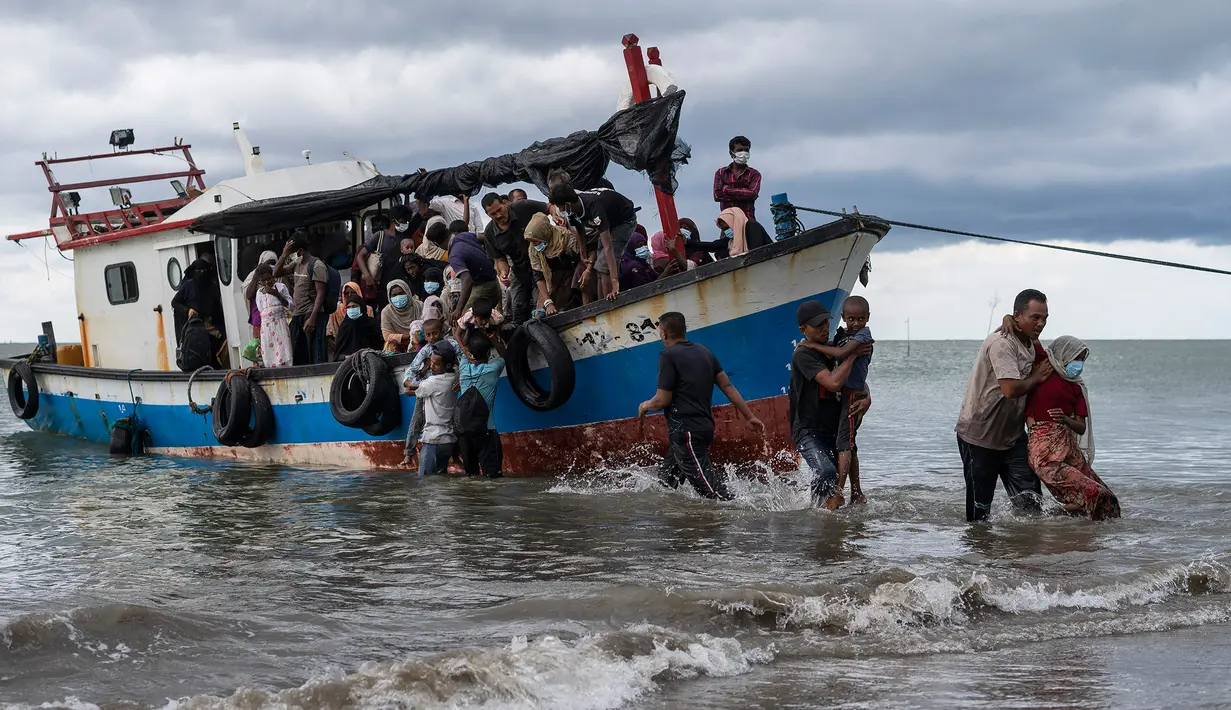 Nelayan membantu mengevakuasi pengungsi etnis Rohingya setibanya di pesisir pantai Lancok, di Kabupaten Aceh Utara, Kamis (25/6/2020). Nelayan Indonesia menemukan hampir 100 orang etnis Rohingya, termasuk 30 orang anak-anak terdampar di tengah laut dengan kondisi kapal rusak. (AP Photo/Zik Maulana)