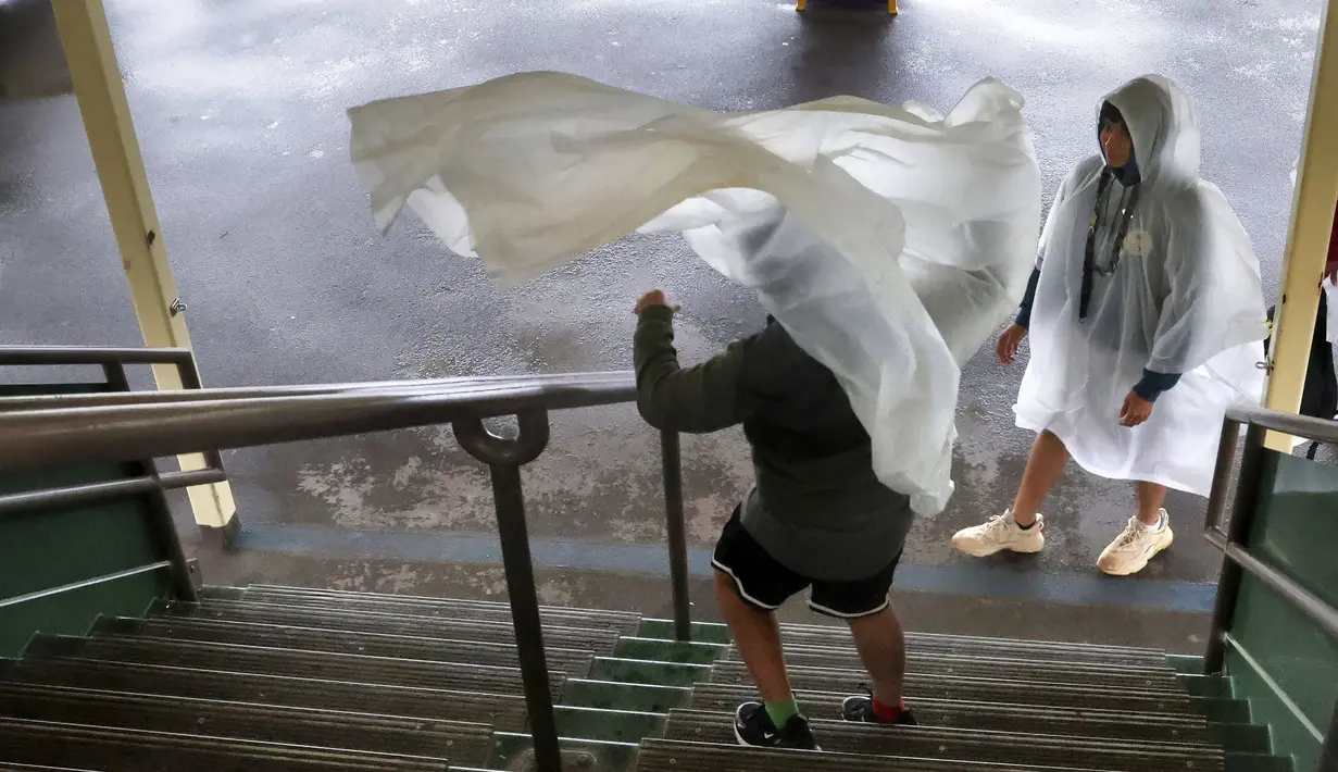 Embusan jendela meniup ponco hujan tamu saat Badai Nicole di kapal feri dalam perjalanan ke Magic Kingdom Walt Disney World di Lake Buena Vista, Florida, Rabu (9/11/2022). Semua taman Disney di Florida Tengah ditutup Rabu pagi karena badai yang akan datang. (Joe Burbank/Orlando Sentinel via AP)