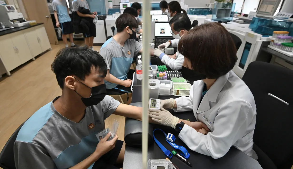 Pemuda Korea Selatan menjalani tes darah saat pemeriksaan medis untuk wajib militer di Administrasi Tenaga Kerja Militer Regional Seoul, Seoul, Korea Selatan, Rabu (1/2/2023). Masa wajib militer untuk tiap orang berbeda-beda karena sejumlah faktor, mulai dari cabang militer tempat mereka berada, tugas aktif, dan non-aktif. (Jung Yeon-je/AFP)