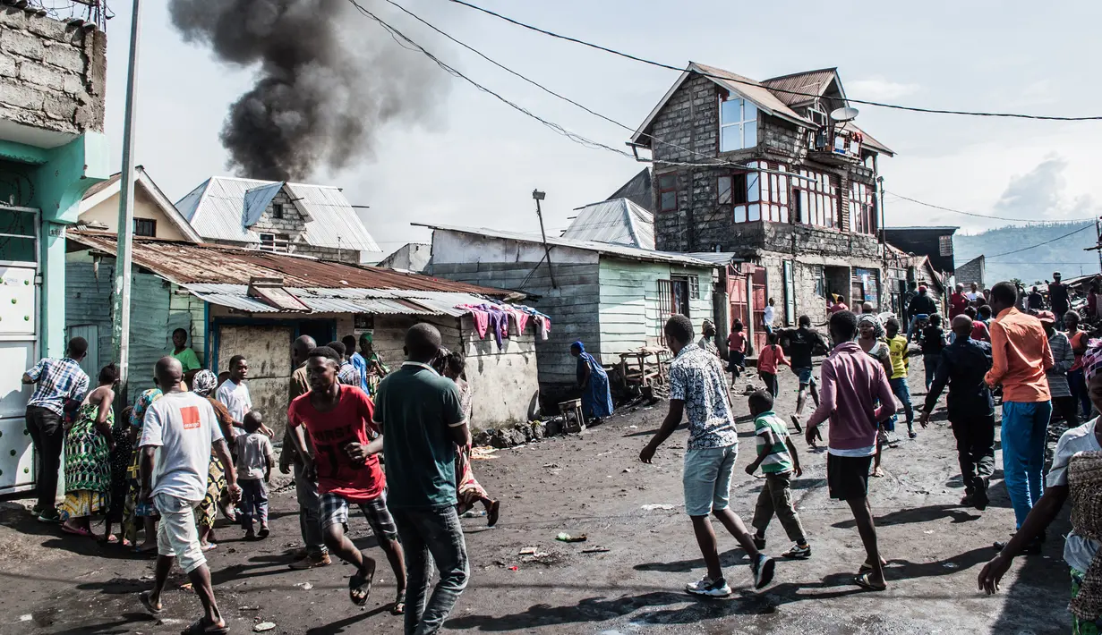 Kepanikan warga saat sebuah pesawat jatuh di kawasan padat penduduk, Goma, Republik Demokratik Kongo, Minggu (24/11/2019). Pesawat tersebut jatuh tak lama setelah lepas landas. (PAMELA TULIZO/AFP)