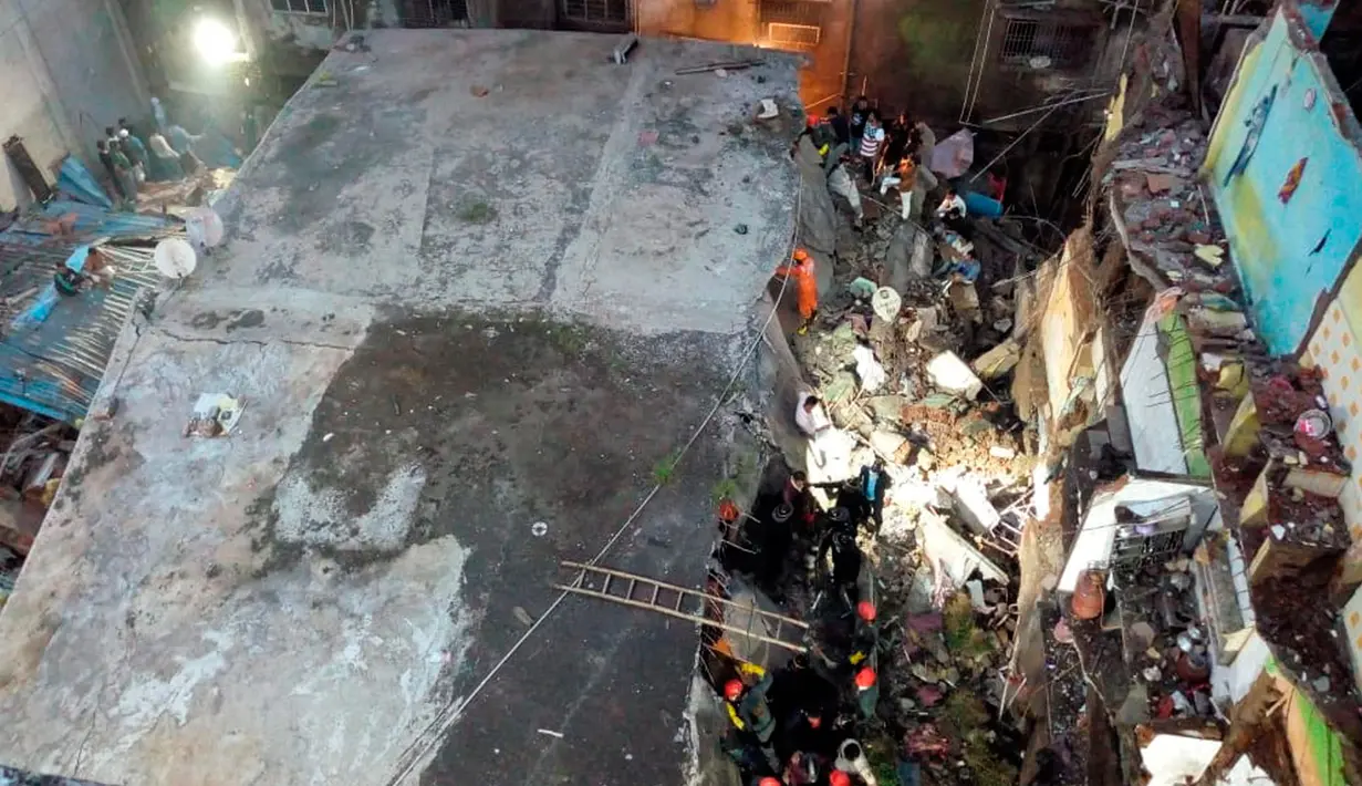 Tim penyelamat berada di lokasi runtuhnya bangunan tempat tinggal tiga lantai di Bhiwandi, Senin (21/9/2020). Belum diketahui penyebab kecelakaan, namun kejadian bangunan ambruk sering terjadi di India selama musim hujan yakni antara Juni dan September. (National Disaster Response Force via AP)