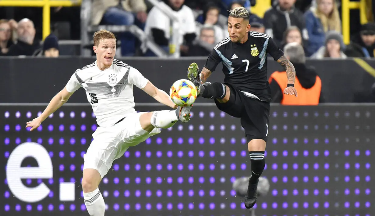 Pemain Jerman, Marcel Halstenberg, berebut bola dengan pemain Argentina, Roberto Pereyra, pada laga persahabatan di Stadion Signal Iduna Park, Rabu (9/10). Kedua tim bermain imbang 2-2. (AP/Martin Meissner)