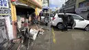 Orang-orang membersihkan toko fotografi setelah hujan lebat mengguyur Tula de Allende, negara bagian Hidalgo, Meksiko, Kamis (9/9/2021). Sedikitnya 16 pasien meninggal setelah banjir melanda sebuah rumah sakit di Meksiko tengah dan mengganggu pasokan listrik. (ALFREDO ESTRELLA/AFP)