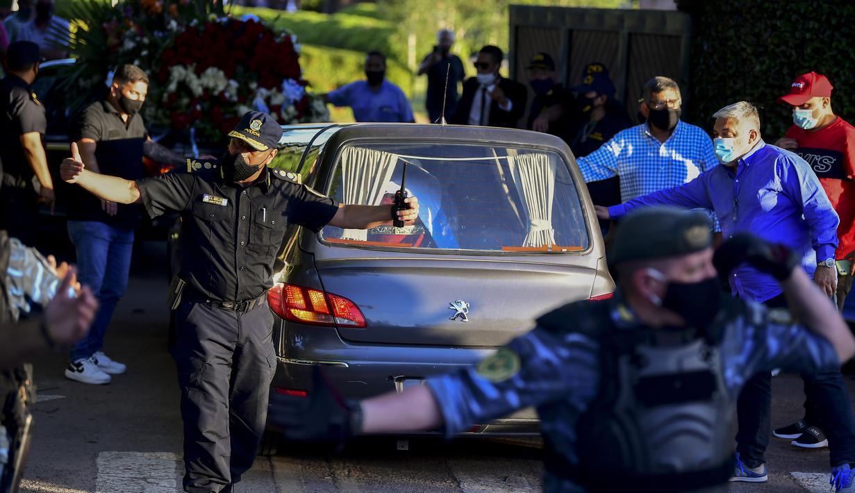 Mobil jenazah legenda sepak bola Argentina, Diego Armando Maradona, tiba di pemakaman Jardin Bella Vista, Kamis (26/11/2020) waktu setempat. Diego Maradona dimakamkan disamping makam kedua orang tuanya, Dalma dan Diego. (AFP/Ronaldo Schemidt)