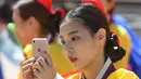 Seorang gadis muda Korea Selatan bermain ponsel selama upacara Coming of Age Day di desa Hanan Namsan di Seoul (21/5). Di usia 19 tahun, mereka diperbolehkan merokok, mengonsumsi minuman beralkohol, dan mengikuti pemilihan umum. (AFP Photo/Jung Yeon-je)
