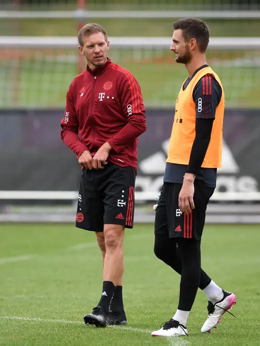 Pelatih baru Bayern Munchen, Julian Nagelsmann (kiri) berbicara dengan penjaga gawang Sven Ulreich selama sesi latihan pertama dengan timnya di tempat latihan mereka di Munich, Jerman selatan (7/7/2021).  (AFP/Christof Stache)
