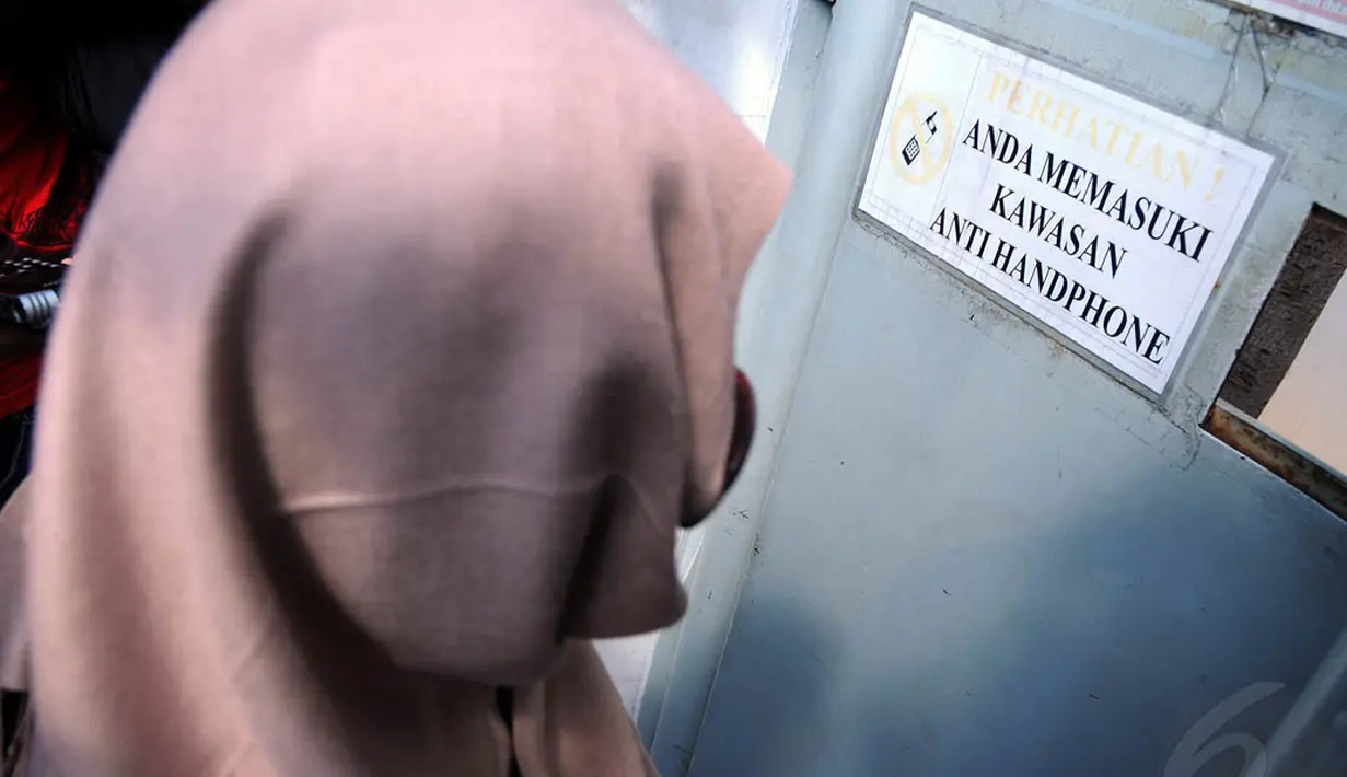 Wanita yang tampil mengenakan kerudung warna krem ini hanya diam saat ditanya awak media soal vonis suaminya. (Liputan6.com/Faisal R Syam)