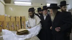Yahudi Ultra-Ortodoks menyiapkan matzoh spesial di sebuah toko roti di Ashdod, Israel, 11 April 2022. Matzoh adalah roti tradisional tidak beragi yang dibuat untuk Paskah. (AP Photo/Tsafrir Abayov)