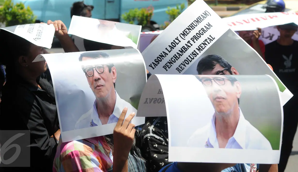 Massa menggunakan poster Menteri Yasonna Laoly untuk berlindung dari sinar matahari saat unjuk rasa di Kantor Kemenkumham Jakarta, Rabu (30/12). Aksi itu mempersoalkan legalitas kepengurusan PPP yang terbagi menjadi dua kubu. (Liputan6.com/Helmi Afandi)