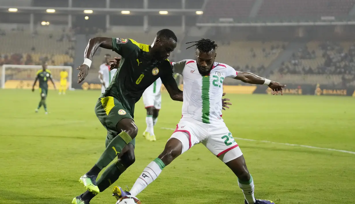 Bek Burkina Faso, Steeve Yago berebut bola dengan pemain Senegal, Cheikhou Kouyate pada pertandingan semifinal Piala Afrika 2022 di stadion Ahmadou Ahidjo di Yaounde, Kamerun, Kamis (3/2/2022). Senegal menang atas Burkina Faso 3-1 dan lolos ke final. (AP Photo/Themba Hadebe)