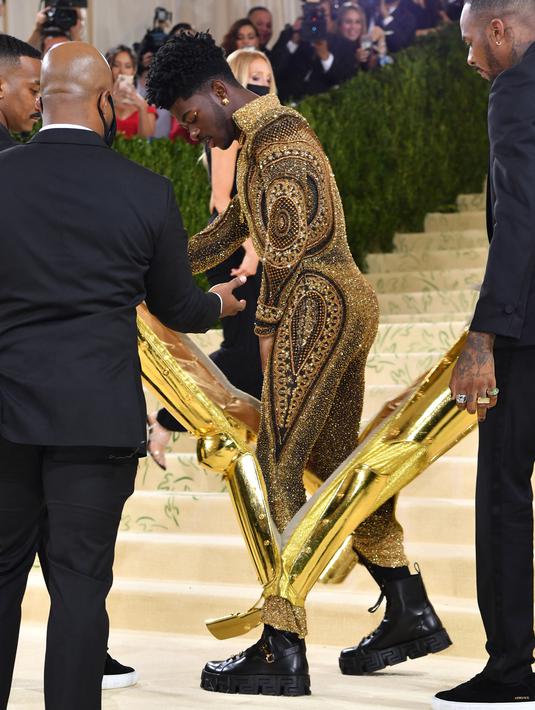 Rapper Lil Nas X menghadiri The 2021 Met Gala Celebrating In America: A Lexicon Of Fashion di Metropolitan Museum of Art, New York City, Senin (13/9/2021). Lil Nas X yang hadir di Met Gala 2021 dengan penuh totalitas tampil menggunakan 3 lapisan kostum sekaligus. (Angela WEISS / AFP)