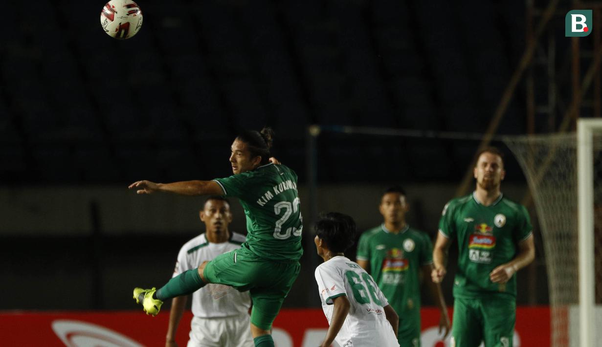 Gelandang PS Sleman, Kim Jeffrey Kurniawan (kiri) menghalau bola di udara saat melawan Persebaya Surabaya dalam laga Grup C Piala Menpora 2021 di Stadion Si Jalak Harupat, Bandung, Rabu (7/4/2021). (Bola.com/Ikhwan Yanuar)