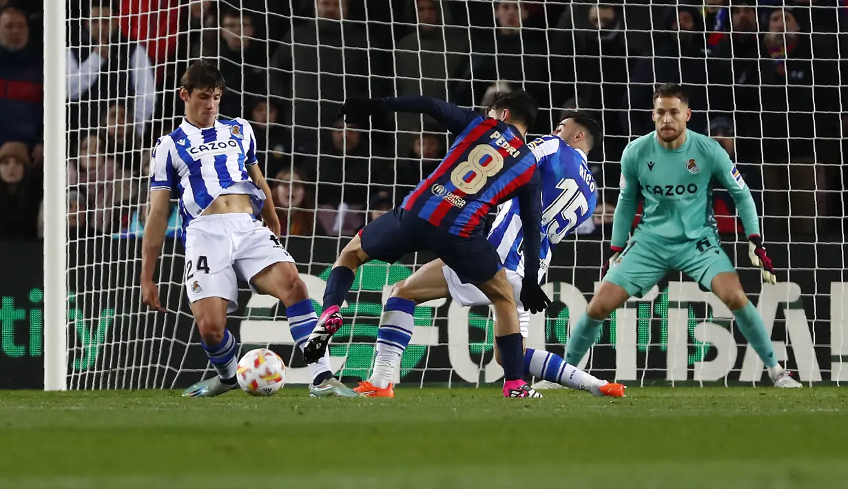 Pedri dari Barcelona (tengah) mengontrol bola dari kawalan dua pemain Real Sociedad, Robin Le Normand dan Diego Rico pada pertandingan perempatfinal Copa del Rey di stadion Camp Nou, di Barcelona, Spanyol, Kamis (26/1/2023). Kemenangan ini mengantar Barcelona melaju ke semifinal. (AP Photo/Joan Monfort)