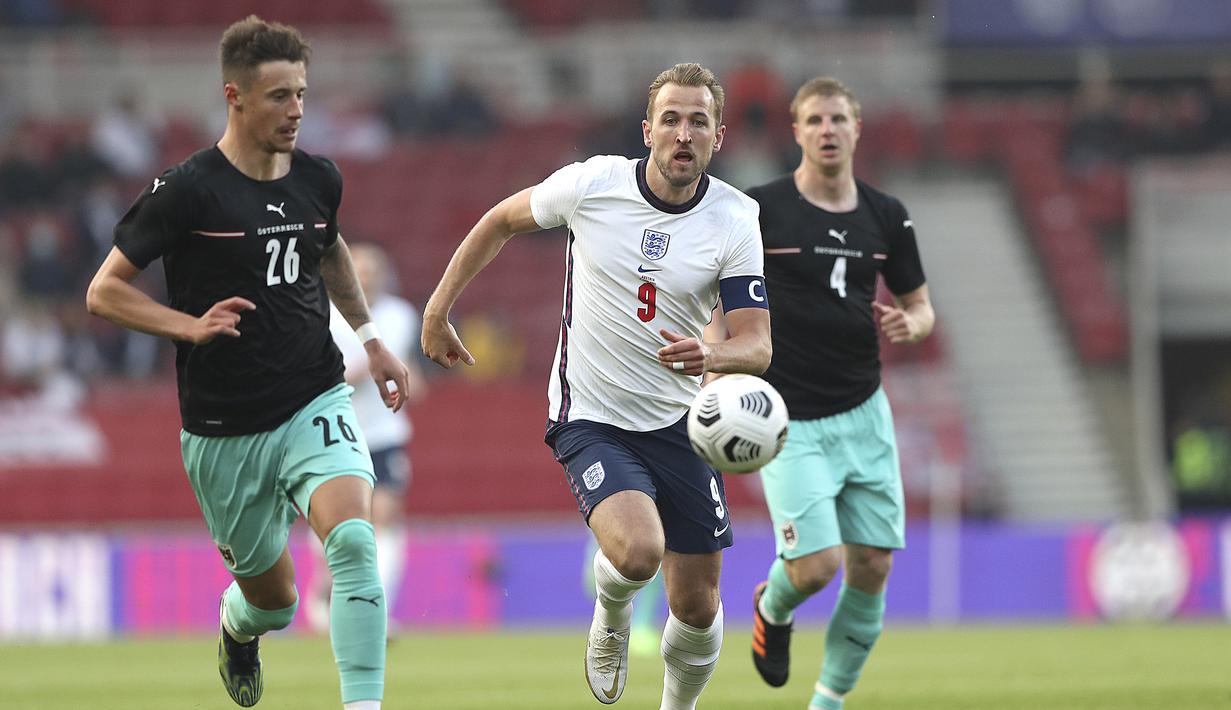 Striker Inggris, Harry Kane (tengah) berebut bola dengan bek Austria, Marco Friedl dalam laga uji coba menjelang berlangsungnya Euro 2020 di Riverside Stadium, Middlesbrough, Rabu (2/6/2021). Inggris menang 1-0 atas Austria. (AP/Scott Heppell/Pool)