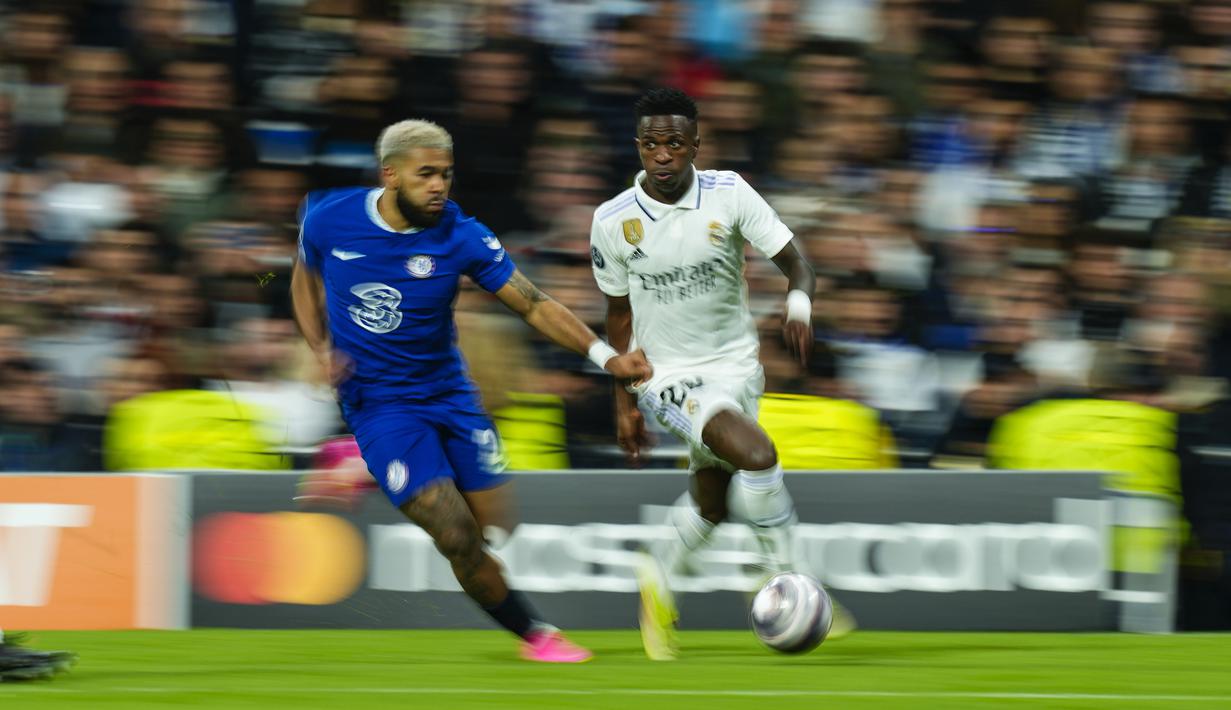 Pemain Real Madrid, Vinicius Junior (kanan), berebut bola dengan pemain Chelsea, Reece James dalam pertandingan leg pertama perempat final Liga Champions 2022/2023 yang berlangsung di Santiago Bernabeu, Kamis (13/4/2023). Vinicius Junior dinobatkan sebagai pemain terbaik pada laga Real Madrid vs Chelsea. Penyerang sayap ini terlibat dalam seluruh gol yang dicetak Madrid ke gawang Chelsea. (AP Photo/Jose Breton)