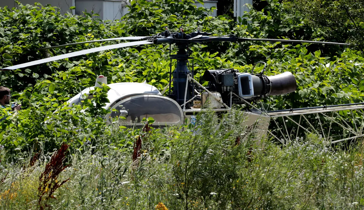 Sebuah helikopter yang ditinggalkan seorang gangster terkenal Prancis, Redoine Faid di Gonesse, utara Paris, Minggu (1/7). Faid kabur dengan bantuan sejumlah pria bersenjata yang mendaratkan helikopter di halaman penjara. (AFP/GEOFFROY VAN DER HASSELT)