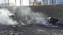 Puing-puing truk militer yang terbakar terlihat di jalan di Kiev, Ukraina, Sabtu (26/2/2022). Pasukan Rusia menyerbu ke arah ibu kota Ukraina pada Sabtu (26/2), dan pertempuran jalanan pecah saat pejabat kota mendesak penduduk untuk berlindung. (AP Photo/Efrem Lukatsky)