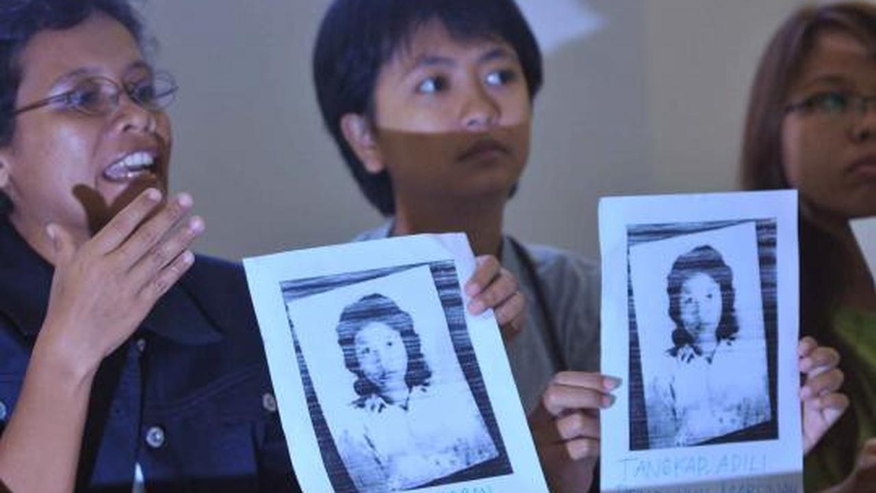 Seorang aktivis menuliskan pesan di foto Marsinah saat konferensi pers 