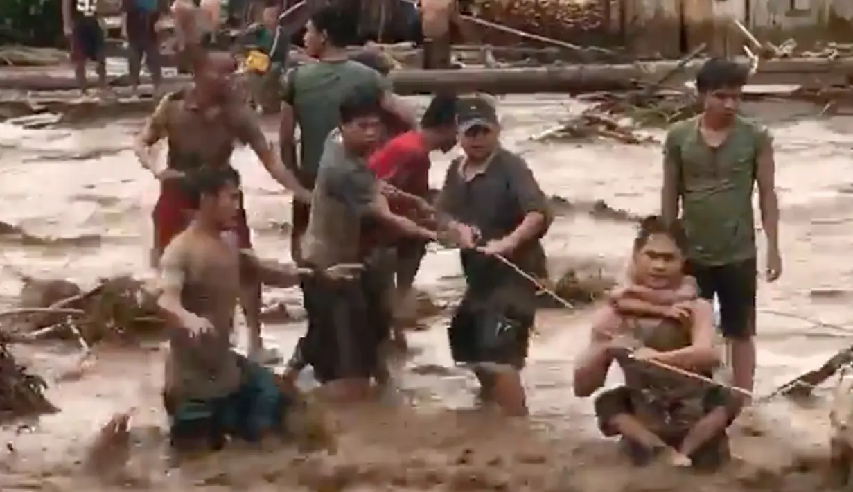 Warga menggunakan tali berusaha menolong korban banjir dahsyat yang melanda Lanao del Norte, Filipina selatan (22/12). Dikutip dari media Filipina, mengabarkan setidaknya 127 korban tewas dalam musibah ini. (Aclimah Disumala via AP)