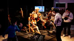 Pengunjung melihat salah satu karya seni yang dipajang dalam pameran anatomi tubuh manusia bertajuk 'Body Worlds' di Moskow, Rusia (24/3/2021). Otoritas Rusia tengah melakukan penyelidikan terkait pameran tersebut. (AFP/Dimitar Dilkoff)