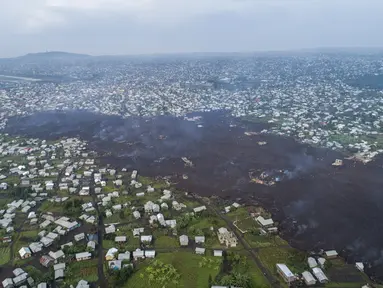 Lava dari letusan Gunung Nyiragongo membelah Buhene di utara Goma, Kongo (24/5/2021). Penduduk kembali ke rumah yang hancur dan mencari orang yang dicintai yang hilang di pinggiran Goma setelah gunung berapi besar itu meletus Sabtu 22 Mei 2021. (AP Photo/Justin Kabumba)
