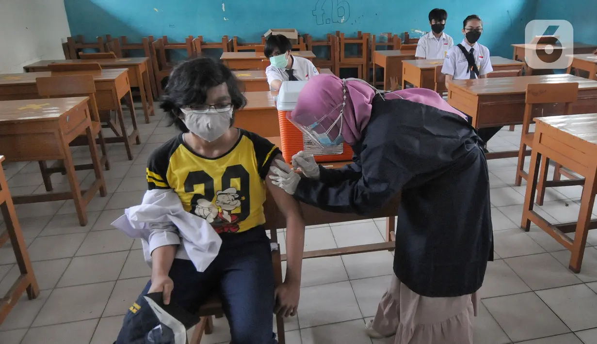 Paramedis memberikan suntikan vaksinasi kepada murid SMP di SMPN 11, Serpong, Tangerang Selatan, Rabu (14/072021). Dinas Kesehatan Tangerang Selatan menggelar vaksinasi COVID-19 perdana, Rabu (14/7/2021) dengan  menargetkan 1.000 pelajar. (merdeka.com/Arie Basuki)