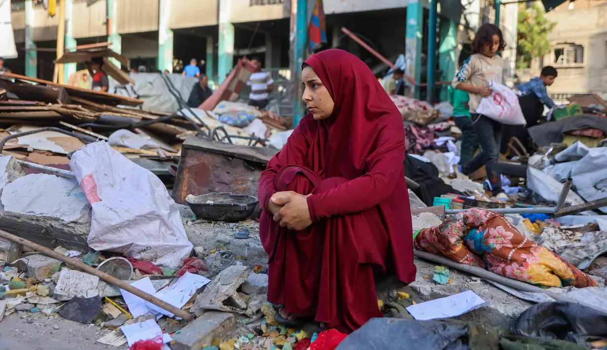 Seorang wanita duduk di antara reruntuhan di sekolah Fahmi Al-Jarjawi, kota Gaza, pada 26 Mei 2025. (Omar AL-QATTAA/AFP)