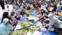 Ribuan masyarakat Garut, Jawa Barat nampak ceria menikmati sajian makan gratis festival 1.000 nasi liwet di Lapang Otista Alun-alun Garut. (Liputan6.com/Jayadi Supriadin)